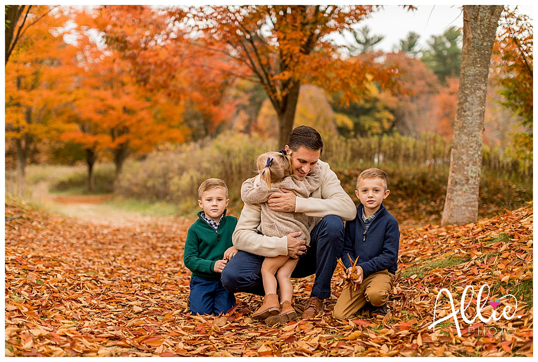 children and dad hugging during fall photos