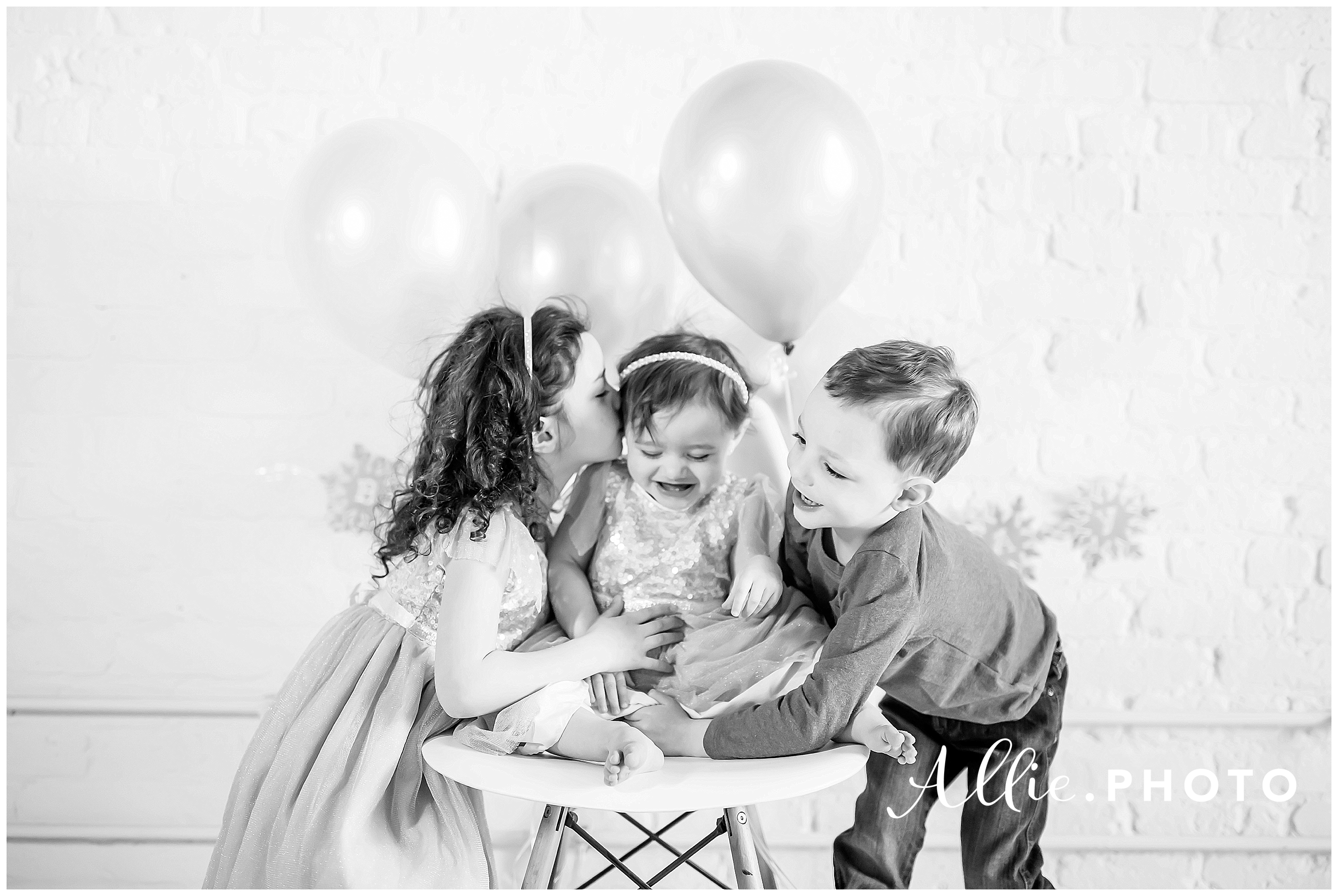siblings-black-white-balloons-smile-kisses-one-year.jpg