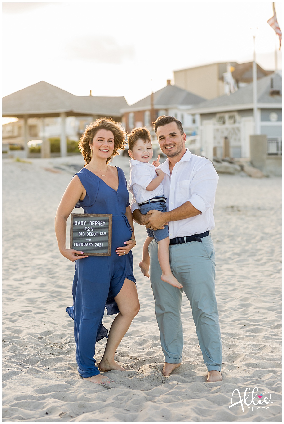 pregnancy announcement at the beach with sign