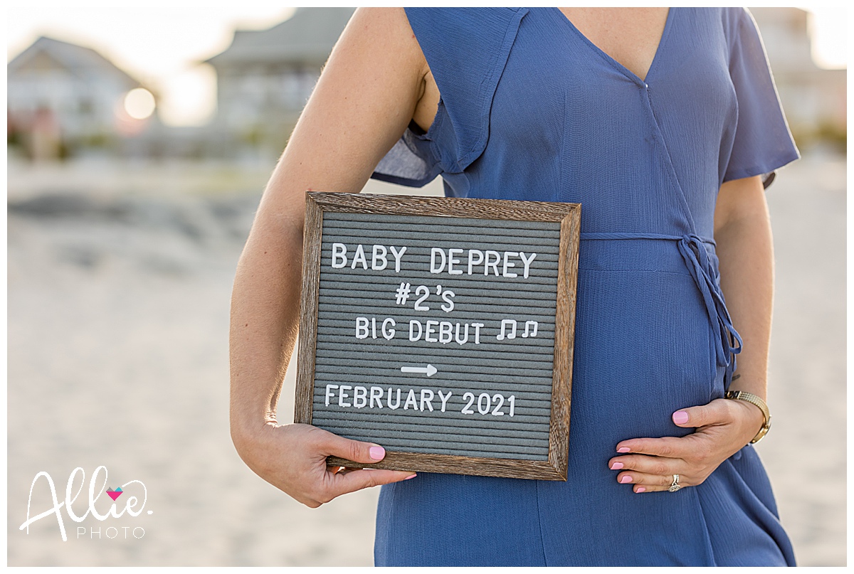 beach pregnancy announcement photos with letter board sign