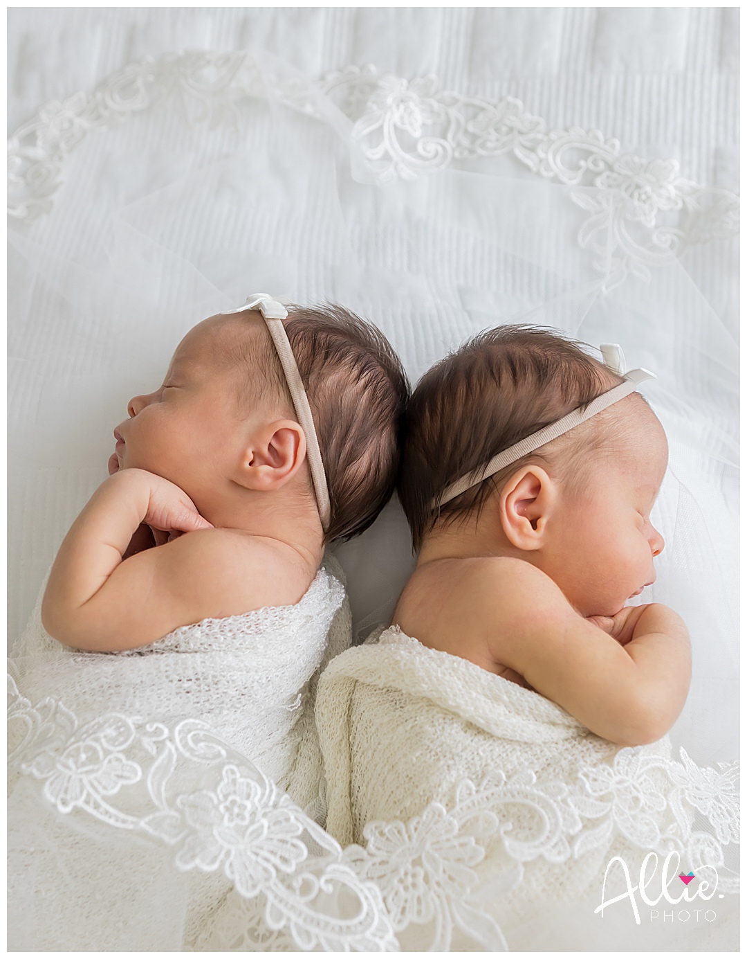 at-home newborn session baby girls with mom's wedding veil