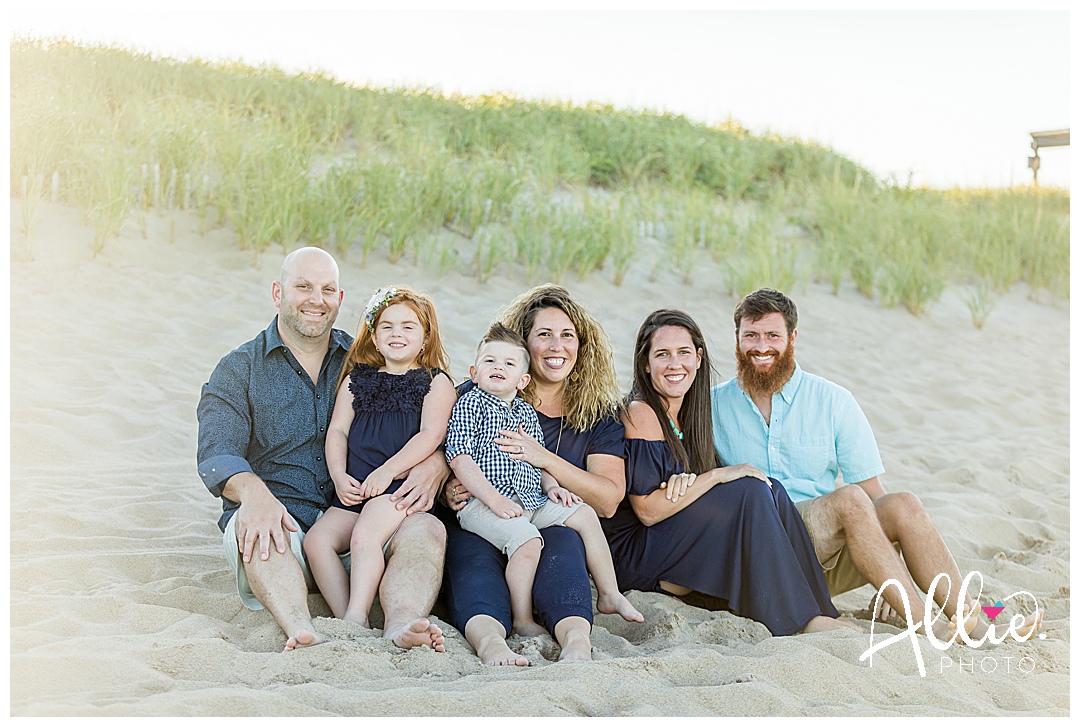 family photo sitting on the beach 